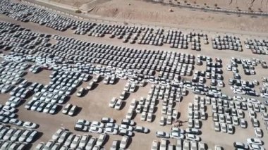 Bekleme platformunda park etmiş koruyucu beyaz çarşaflarla kaplı yeni arabalar..