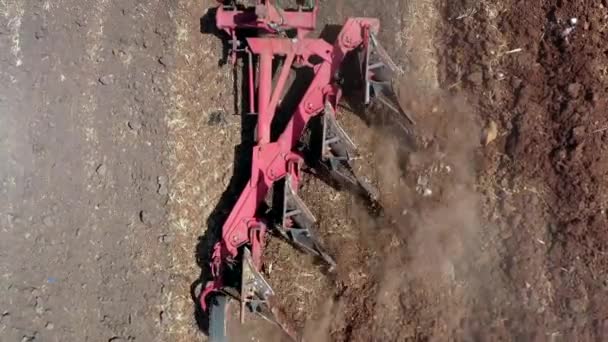 Luchtopname van een ploeg die een droog bodemveld verwerkt. — Stockvideo