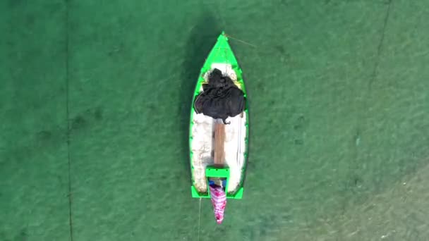 Petit bateau de pêche ancré dans un lagon peu profond, avec filet de poisson emballé à bord. — Video