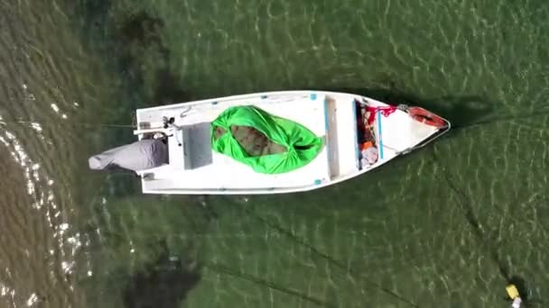 Kleines Fischerboot vor Anker in einer flachen Lagune, mit gepackten Fischernetzen an Bord. — Stockvideo