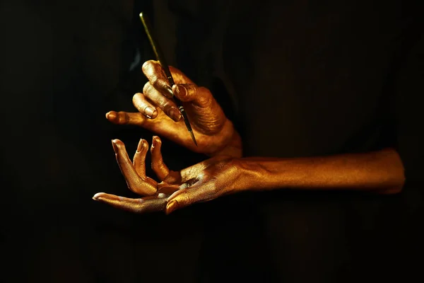 Siyah arka plan üzerine izole altın eller witn fırça — Stok fotoğraf