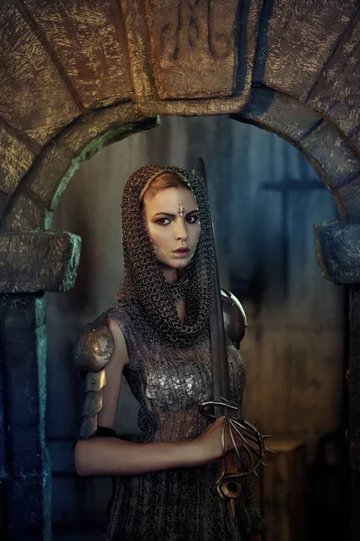 Bir güzel savaşçı kız kılıç ve zırh. Bir zincir etek ve yelek gizemli ayların içinde modelinde. Fantezi fotoğraf.