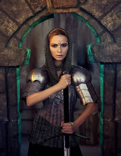 Bir güzel savaşçı kız kılıç ve zırh. Bir zincir etek ve yelek gizemli ayların içinde modelinde. Fantezi fotoğraf.
