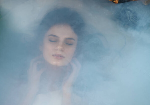 close portrait of a girl in smoke lying on her back