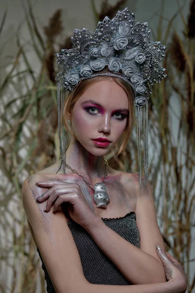 Chica en maquillaje de plata y labios rojos en tocado de plata en el fondo de la naturaleza — Foto de Stock