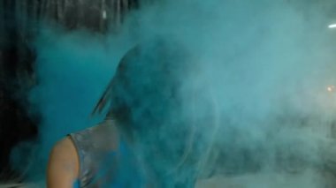 karanlık bir arka planda bir Holi boya bulutu genç güzel kız, yavaş hareket