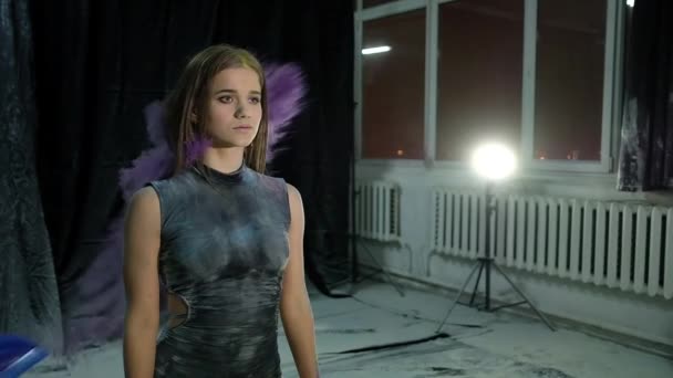 Fiatal gyönyörű lány egy Holi festék felhő egy sötét háttér, lassú mozgás — Stock videók