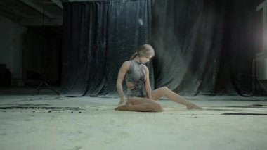 Siyah bodysuit genç güzel kız un bir bulutta unu ve hamle atar. Yavaş hareket.