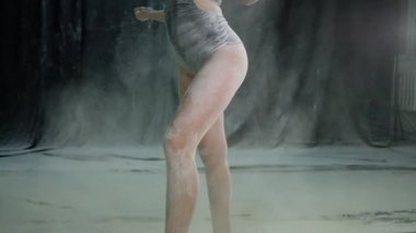 Siyah bodysuit genç güzel kız un bir bulutta unu ve hamle atar. Yavaş hareket.