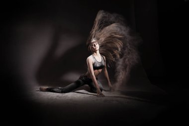 Siyah arka planda un dansı yapan bir kız.