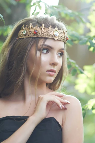 ormanda bir taç ile siyah elbiseli genç, güzel kız