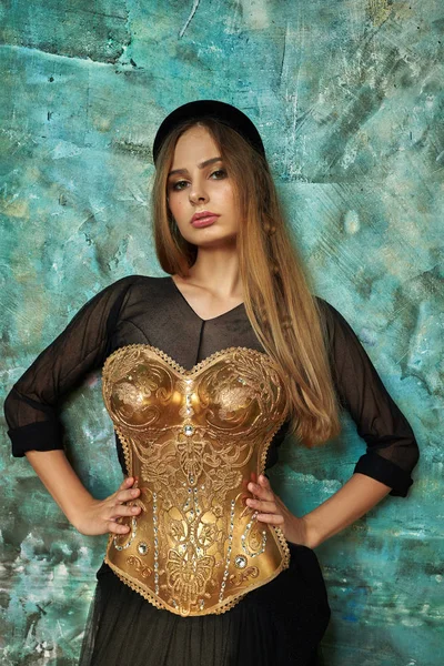 siyah elbiseli kız ve mavi duvara karşı altın korse