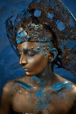  altın mavi yaratıcı makyaj ve başlık bir kız