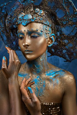  altın mavi yaratıcı makyaj ve başlık bir kız
