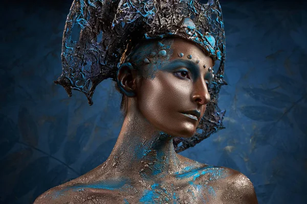 Una chica en oro azul maquillaje creativo y tocado — Foto de Stock