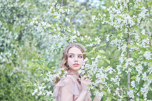 Young beautiful girl near a flowering tree