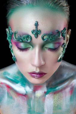 yeşil ve mor çiçekleryaratıcı makyaj ile genç güzel kız