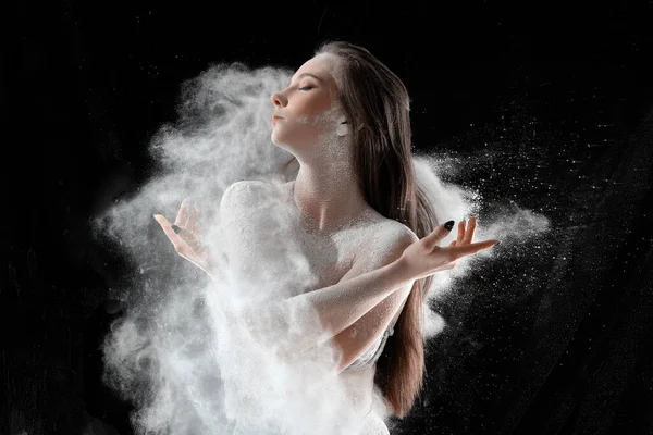 Flicka dansar med mjöl på svart bakgrund en person — Stockfoto