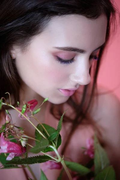 Portret van jong mooi meisje in een roze jurk met bloemen — Stockfoto