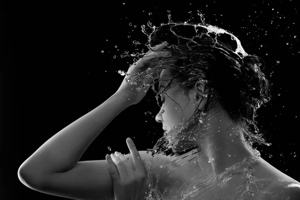 きれいな肌と水のスプラッシュを持つ若い女性。顔の周りに水の滴を持つ女性の肖像画黒と白 — ストック写真
