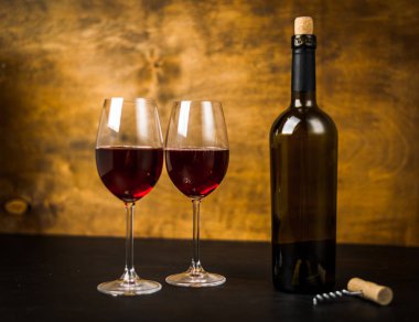 bir şişe şarap ve ahşap arka plan üzerinde iki bardak