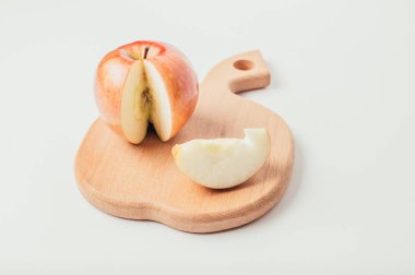 Taze kırmızı kesme ahşap tahta ve karanlık Tekstil arka plan üzerinde elma parçalara kesilmiş.