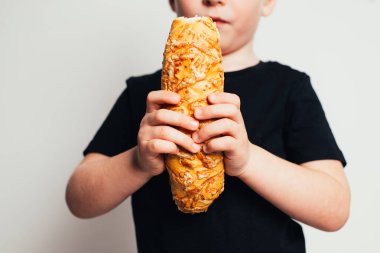 siyah t-shirt holding ekmek beyaz duvar önünde küçük çocuk kırpılmış görüntü