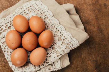 Close-up view of raw chicken eggs on  wooden background