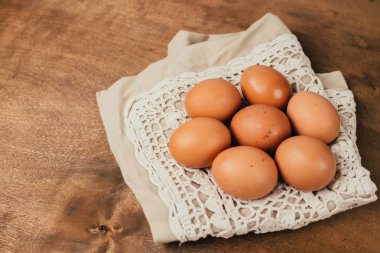 Close-up view of raw chicken eggs on  wooden background