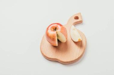 Taze kırmızı kesme ahşap tahta ve karanlık Tekstil arka plan üzerinde elma parçalara kesilmiş.