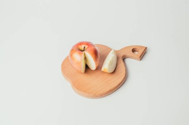 Taze kırmızı kesme ahşap tahta ve karanlık Tekstil arka plan üzerinde elma parçalara kesilmiş.