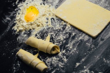 Malzemeler ve unlu mamüller - un, hamur, yumurta, oklava, çırpma teli, süzgeç, hazırlanması için mutfak eşyaları - ücretsiz kopya alanı siyah masada ekmek