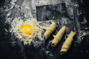 Malzemeler ve unlu mamüller - un, hamur, yumurta, oklava, çırpma teli, süzgeç, hazırlanması için mutfak eşyaları - ücretsiz kopya alanı siyah masada ekmek