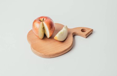 Taze kırmızı kesme ahşap tahta ve karanlık Tekstil arka plan üzerinde elma parçalara kesilmiş.