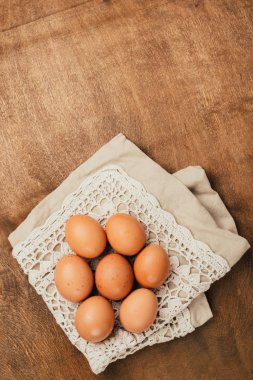 Close-up view of raw chicken eggs on  wooden background