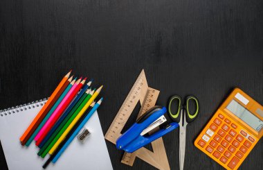 siyah yüzey üzerinde yükseltilmiş görünümü çeşitli okul malzemeleri ve renkli kalemler
