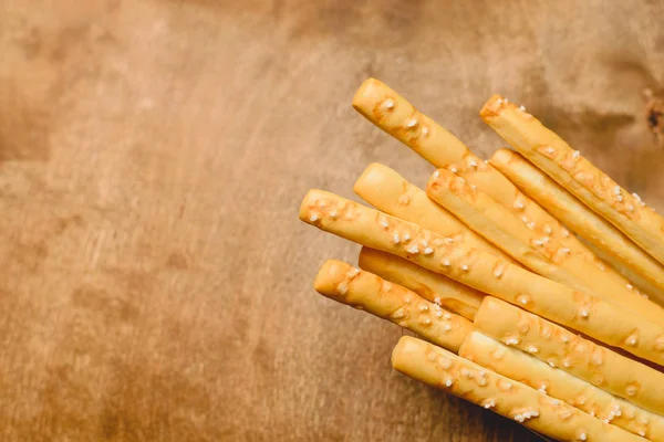 Traditional Italian snack, bread - grissini. On a dark stone table, top view, copy space