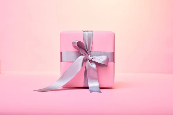 Arka plan üzerinde pembe hediye kutusu