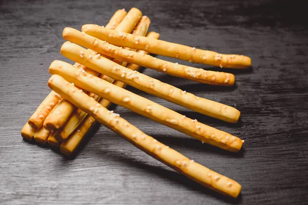 Traditional Italian snack, bread - grissini. On a dark stone table, top view, copy space