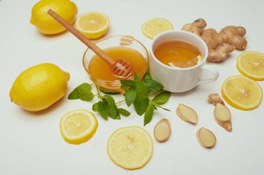 Kupası çay, bal kase, zencefil, limon ve nane beyaz masaya yakın çekim