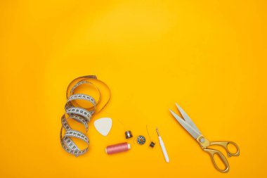 makas, bant ölçüm ve sarı zemin üzerine dizeleri yukarıdan görüntülemek