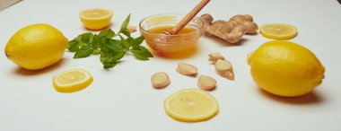 bal, kase, zencefil, limon ve nane beyaz masaya yakın çekim