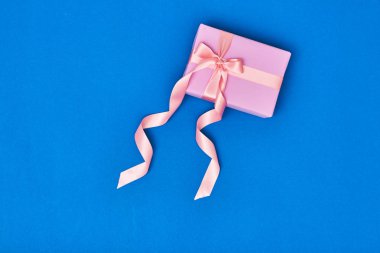 Arka plan üzerinde pembe hediye kutusu