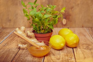 bal kase, zencefil, limon ve nane ahşap masa üzerinde tencerede yakın çekim