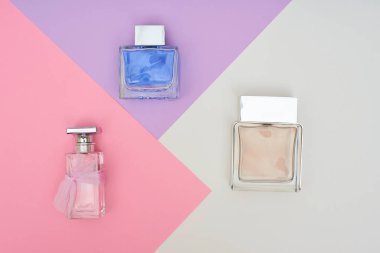 Pastel arka plan üzerinde parfüm şişeleri. En az stili.