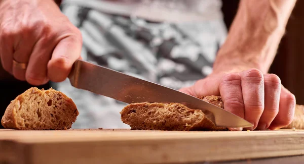 Chleb Pełnoziarnisty Nakładany Kuchenną Drewnianą Płytę Kucharzem Trzymającym Złoty Nóż — Zdjęcie stockowe