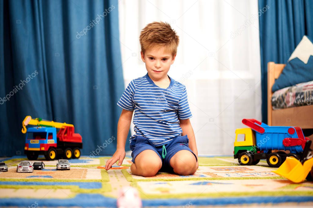 little boy playing with toys on carpet at home