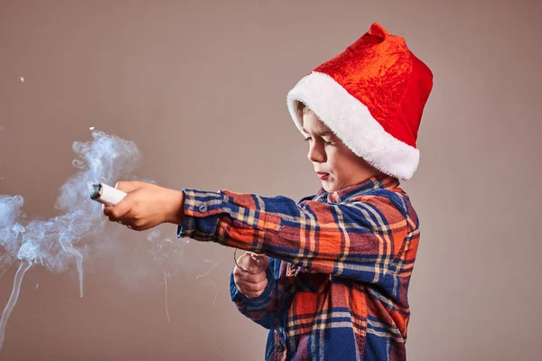 演播室拍摄的小男孩在圣诞老人帽子爆炸党爆爆的党爆料 免版税图库图片