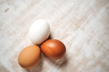 beyaz ve kahverengi ham tavuk yumurtası üstten görünüm masa üzerinde  