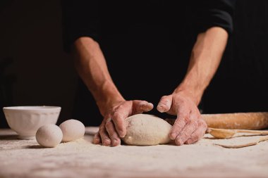 ahşap masa üzerinde hamur yoğurma adam orta bölümünde 